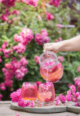Taze limonata ya da buzlu kikuyruk ve doğal bahçedeki taze güller.