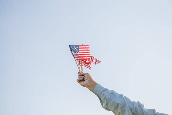 Старший патриот празднует День независимости США 4 июля с национальным флагом в руках. Конституция и День гражданства. Национальный день бабушки и дедушки