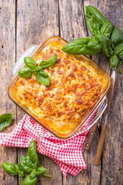 Geleneksel İtalyan lazanyası sebze, fesleğen, kıyma, domates ve peynirli ahşap zemin..