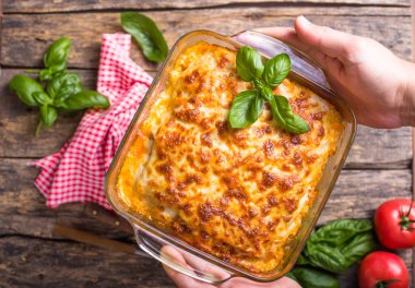 Geleneksel İtalyan lazanyası sebze, fesleğen, kıyma, domates ve peynirli ahşap zemin..