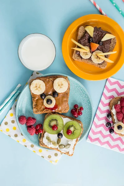 Funny breakfast toast for kids shaped as cute cat, dog, bear, fish. Food art sandwich for child. Isolated. Animal faces toasts with spreads, fruits