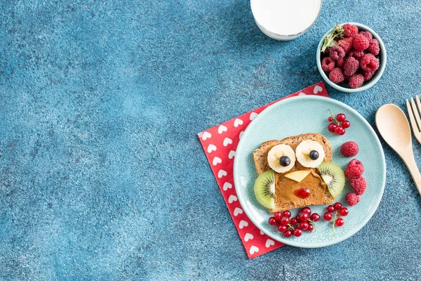 Funny breakfast toast for kids shaped as cute owl. Food art sandwich for child. Isolated. Animal faces toasts with spreads, fruits