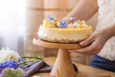 Karamelli elmalı cheesecake ile süslenmiş mumlu bir kadın. Sonbahar tatlısı. Elmalı karamelli cheesecake, tatlı yemek..