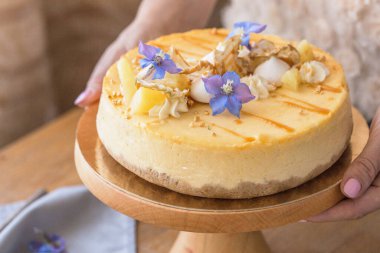 Karamelli elmalı cheesecake ile süslenmiş mumlu bir kadın. Sonbahar tatlısı. Elmalı karamelli cheesecake, tatlı yemek..
