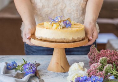 Karamelli elmalı cheesecake ile süslenmiş mumlu bir kadın. Sonbahar tatlısı. Elmalı karamelli cheesecake, tatlı yemek..
