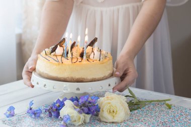 Karamelli elmalı cheesecake ile süslenmiş mumlu bir kadın. Sonbahar tatlısı. Elmalı karamelli cheesecake, tatlı yemek..