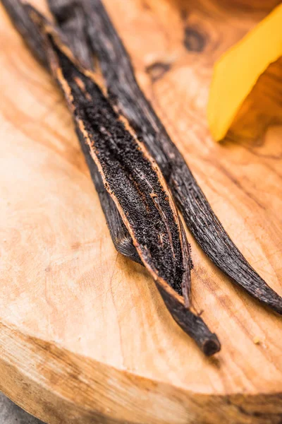 Dried vanilla pods on wooden table. Close-up.