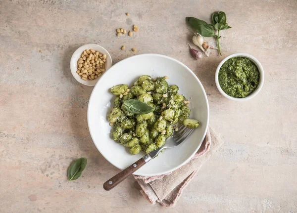 İtalyan yemeği: pesto soslu ev yapımı gnocchi ve beton masada fesleğen.