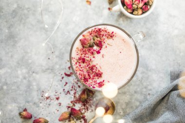 Sütlü pembe kibritli latte. Moda içeceği. Parıltılı ışıklarla süslenmiş Noel içkisi.