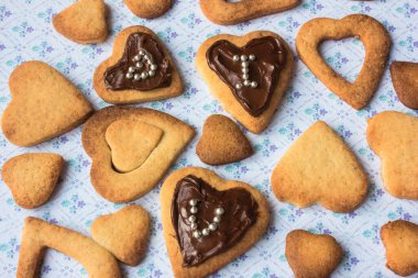 Ahşap masada ev yapımı kalp şeklinde kurabiyeler. 