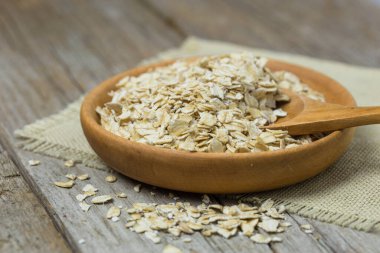 Kuru yulaf ezmesi, ahşap arka planda yulaf ezmesi. Sağlıklı vejetaryen yemeği. Temiz yemek, diyet, kilo verme konsepti