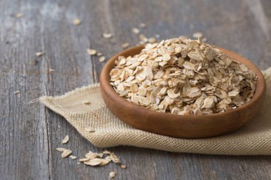 Kuru yulaf ezmesi, ahşap arka planda yulaf ezmesi. Sağlıklı vejetaryen yemeği. Temiz yemek, diyet, kilo verme konsepti