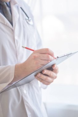Erkek doktor panoya yazı yazıyor. Genç, beyaz, erkek, profesyonel tıp uzmanı..