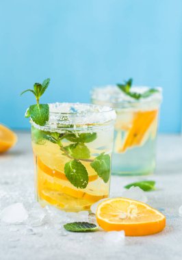 Limonlu limonata suyu. Sağlıklı dilimlenmiş ve detoks suyu. Yazın mavi arka planda.