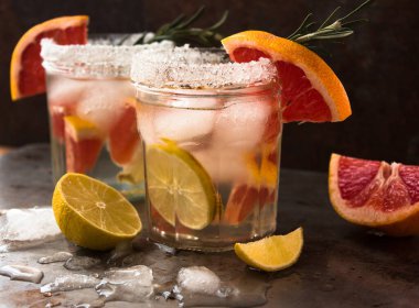 Taze meyvelerden oluşan alkolsüz detoks kokteyli: greyfurt, limon, sağlıklı bir içeceğin biberiye konsepti. Paslı metal arkaplan