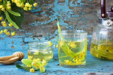 Mavi arkaplanda ıhlamur çiçeği ve ıhlamur balı, çaydanlık. Taze ıhlamur.