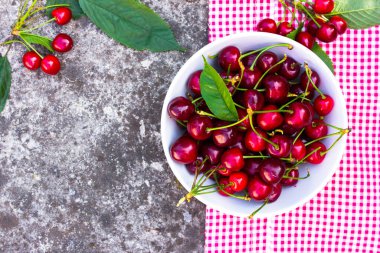 Kırsal beton arka planda, kasede taze kiraz meyvesi.