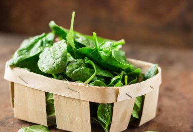 Tahta masadaki taze organik ıspanak yaprakları. Diyet, diyet konsepti. Vejetaryen yemeği, sağlıklı yemek..