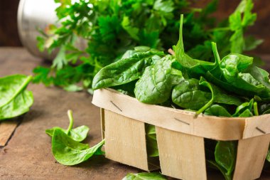 Tahta masadaki taze organik ıspanak yaprakları. Diyet, diyet konsepti. Vejetaryen yemeği, sağlıklı yemek..