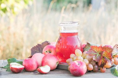 Ahşap Arkaplan 'da ev yapımı elma suyu, meyve suyu veya üzüm suyu.