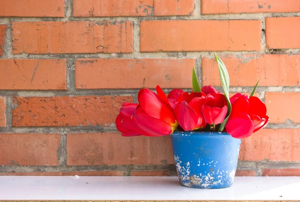 Ramo Tulipanes Rojos Maceta Azul Sobre Fondo Pared Ladrillo Viejo —  Fotos de Stock