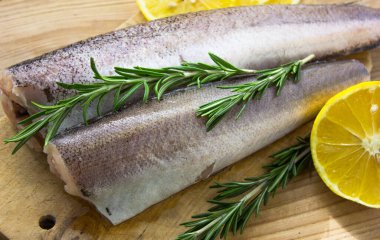 Çiğ balık yahnisi. Saman ve tahtadan oluşan bir arka plan. Limon, baharat, zeytinyağı..