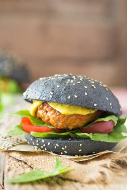 Biftek, ıspanak, domates ve soslu kara hamburger.