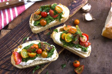 Domatesli İtalyan bruschetta, fesleğen, peynir ve zeytinyağı. Ahşap zemin üzerinde taze ev yapımı caprese veya crostini