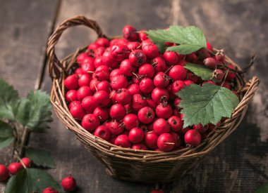 Tahta bir masanın üzerinde duran sepetteki taze dikenli kırmızı böğürtlenler. Boşluğu kopyala.