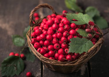 Tahta bir masanın üzerinde duran sepetteki taze dikenli kırmızı böğürtlenler. Boşluğu kopyala.