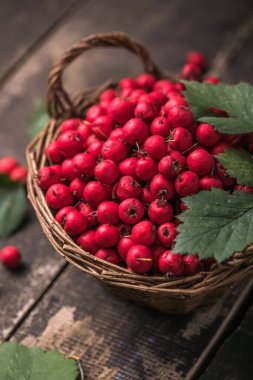 Tahta bir masanın üzerinde duran sepetteki taze dikenli kırmızı böğürtlenler. Boşluğu kopyala.