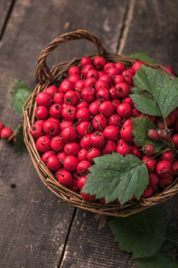 Tahta bir masanın üzerinde duran sepetteki taze dikenli kırmızı böğürtlenler. Boşluğu kopyala.