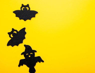 Canlı sarı arka planda cadılar bayramı dekorasyonu çerçevesi. Yassı örümcekler, yarasalar, böcekler yatıyordu. Kopyalama alanı olan üst görünüm. Tatil tebrik kartı modeli..