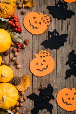 Pastel beyaz arka planda cadılar bayramı dekorasyonu çerçevesi. Turuncu balkabakları, ürkütücü örümcekler, yarasalar, böcekler yatıyordu. Kopyalama alanı olan üst görünüm. Tatil tebrik kartı modeli..