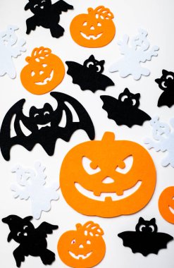 Pastel beyaz arka planda cadılar bayramı dekorasyonu çerçevesi. Turuncu balkabakları, ürkütücü örümcekler, yarasalar, böcekler yatıyordu. Kopyalama alanı olan üst görünüm. Tatil tebrik kartı modeli..