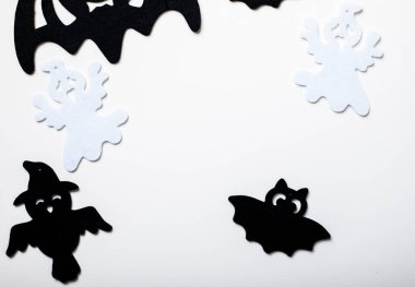 Pastel beyaz arka planda cadılar bayramı dekorasyonu çerçevesi. Yassı örümcekler, yarasalar, böcekler yatıyordu. Kopyalama alanı olan üst görünüm. Tatil tebrik kartı modeli..