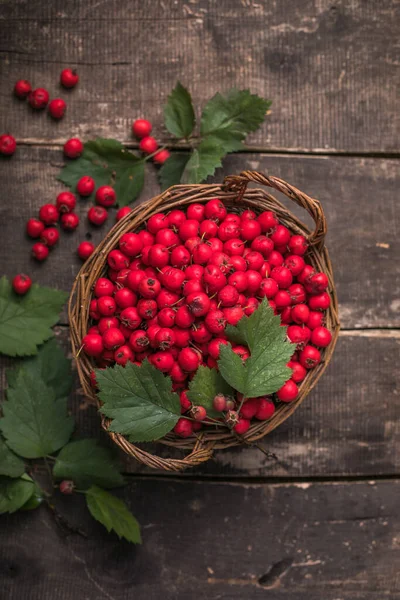 Tahta bir masanın üzerinde duran sepetteki taze dikenli kırmızı böğürtlenler. Boşluğu kopyala.