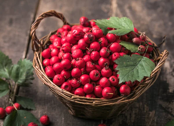 Tahta bir masanın üzerinde duran sepetteki taze dikenli kırmızı böğürtlenler. Boşluğu kopyala.