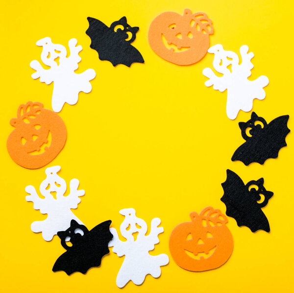 Рамка Хэллоуина украшения на ярком желтом фоне. Плоские лежали оранжевые тыквы, жуткие пауки, летучая мышь, насекомые. Вид сверху с пространством для копирования. Макет праздничных открыток.