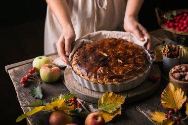 Taze meyve, fındık ve elmalarla çevrili ev yapımı elmalı turta.