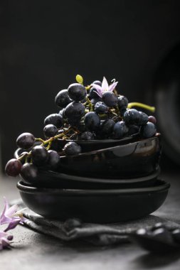 Siyah arka planda, üzümlü, boş, yuvarlak siyah bir plaka. Boşluğu kopyala. 