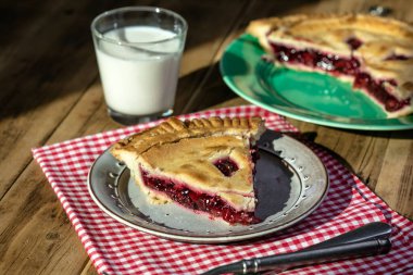 Rustic cherry pie with milk on wooden background, homemade dessert style