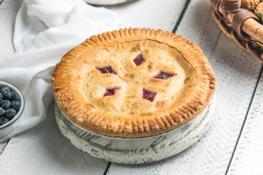 Beyaz ahşap tahtalarda vişneli ve yaban mersinli turta, ev yapımı kırsal tatlı.