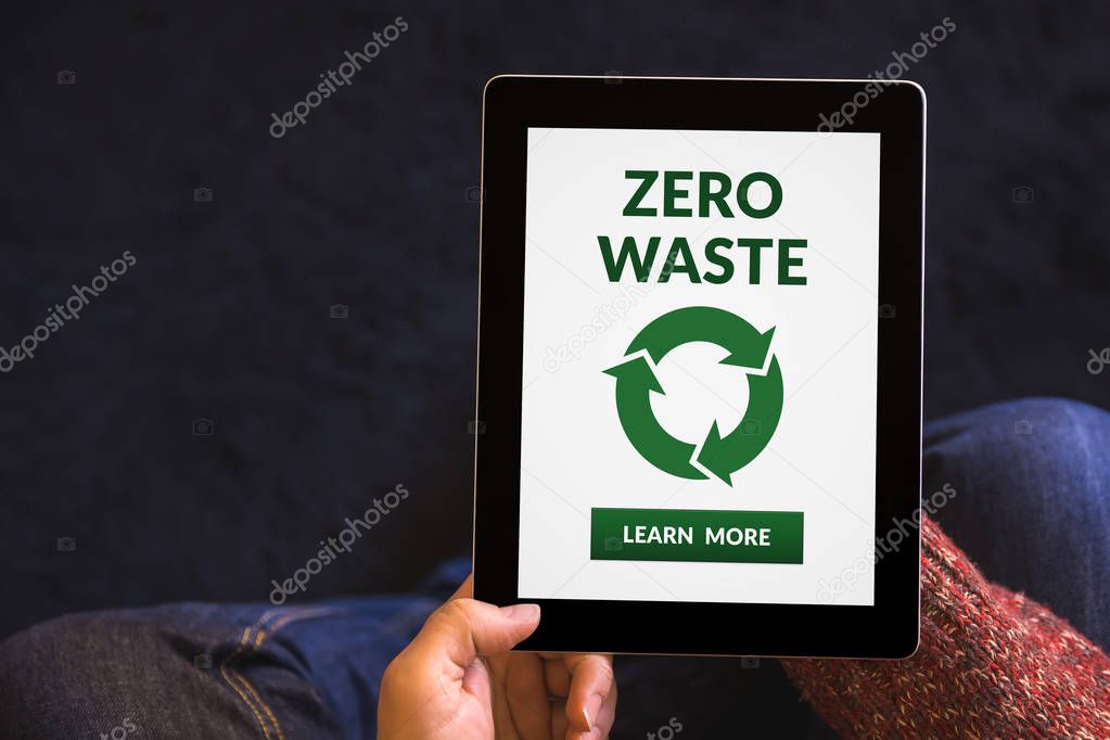 Hands holding digital tablet computer with zero waste concept on screen. All screen content is designed by me. Top view