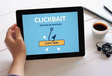 Clickbait konsepti ile dijital tablet bilgisayar ekranında tutan el. Tüm ekran içerik bana tarafından tasarlanmıştır