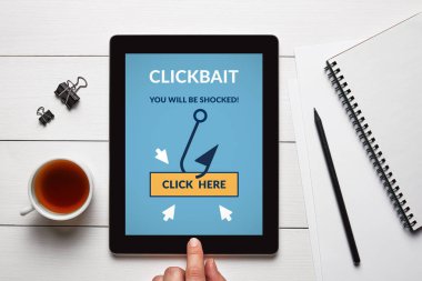 Beyaz ahşap masa üzerinde office nesneleri clickbait konseptiyle tablet ekranında. Tüm ekran içerik bana tarafından tasarlanmıştır. Düz yatıyordu