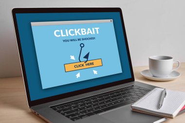 Ahşap masa üzerinde modern dizüstü bilgisayar ekranında clickbait kavramı. Tüm ekran içerik bana tarafından tasarlanmıştır. 