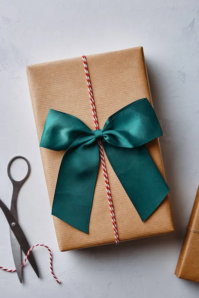 クリスマス プレゼントは 麻ひも 弓とはさみで茶色の紙に包まれました 上からの眺め — ストック写真