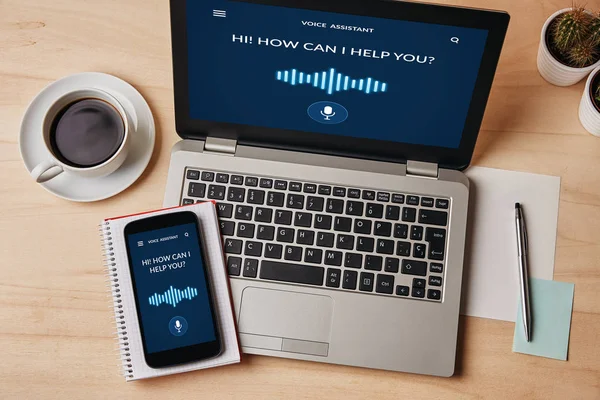 Ses asistanı kavramı üzerinde ahşap masa laptop ve smartphone ekranında. Tüm ekran içerik bana tarafından tasarlanmıştır. Düz yatıyordu