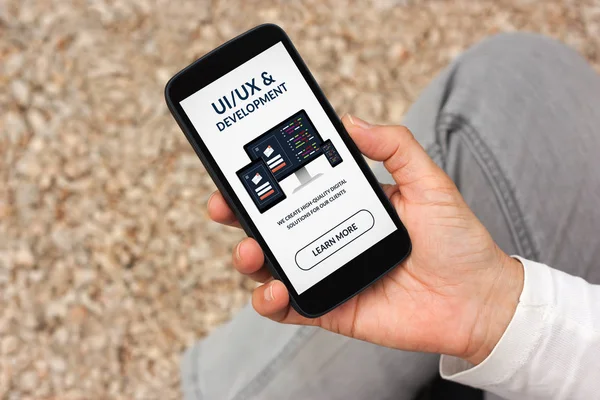 Руки, що тримає смарт-телефон з Ui/Ux дизайн та розробка концепції — стокове фото